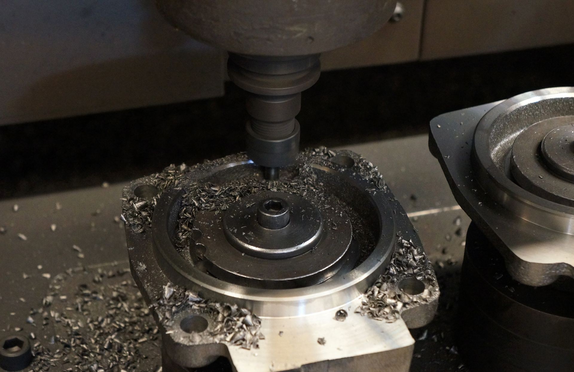 The end-mill tool cutting the machine part by CNC milling machine.